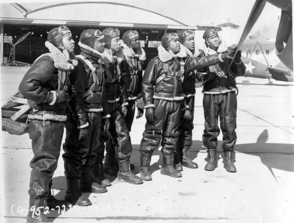 Tuskegee Airmen investigating plane propeller